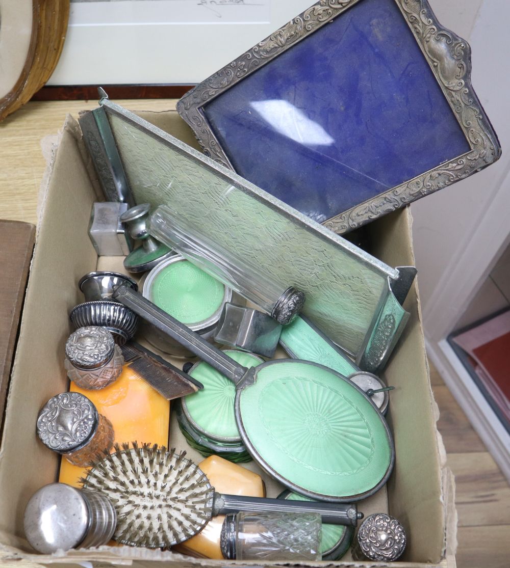A silver mounted photograph frame, silver lidded cut glass toilet jars and an Art Deco toilet set